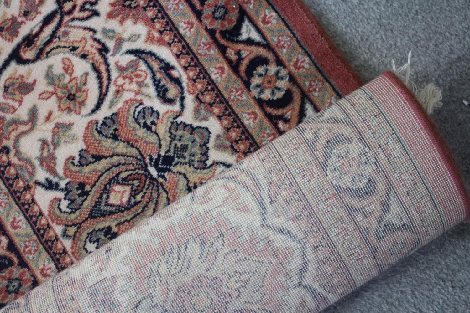 A Keshan motif woollen carpet with central medallion and trailing foliate pattern on a burgundy - Image 4 of 5