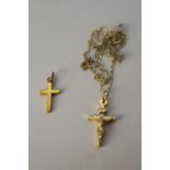 A yellow metal (tests higher than 9 carat) crucifix along with a 9 carat gold crucifix on a 9