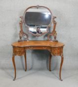 A late Victorian carved mahogany dressing table with adjustable plate raised on cabriole supports.