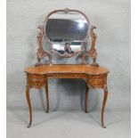 A late Victorian carved mahogany dressing table with adjustable plate raised on cabriole supports.