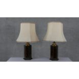 A pair of lacquered tortoiseshell effect hexagonal table lamps with gilded linear detailing. Each