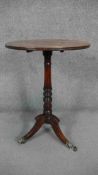 A 19th century mahogany occasional table on ring turned central column resting on swept tripod base.