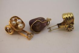 Three gold charms. Including a 14 carat golden rickshaw with canopy, a yellow metal (tested 14