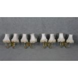 a set of four brass twin branch scrolling design wall lights with cream silk shades and tassel