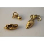 Four 14 carat yellow gold charms. Including a gold clog charm set with turquoise cabochons, a gold