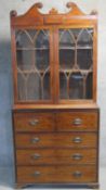 A 19th century mahogany two section secretaire bookcase with scrolling swan neck pediment above