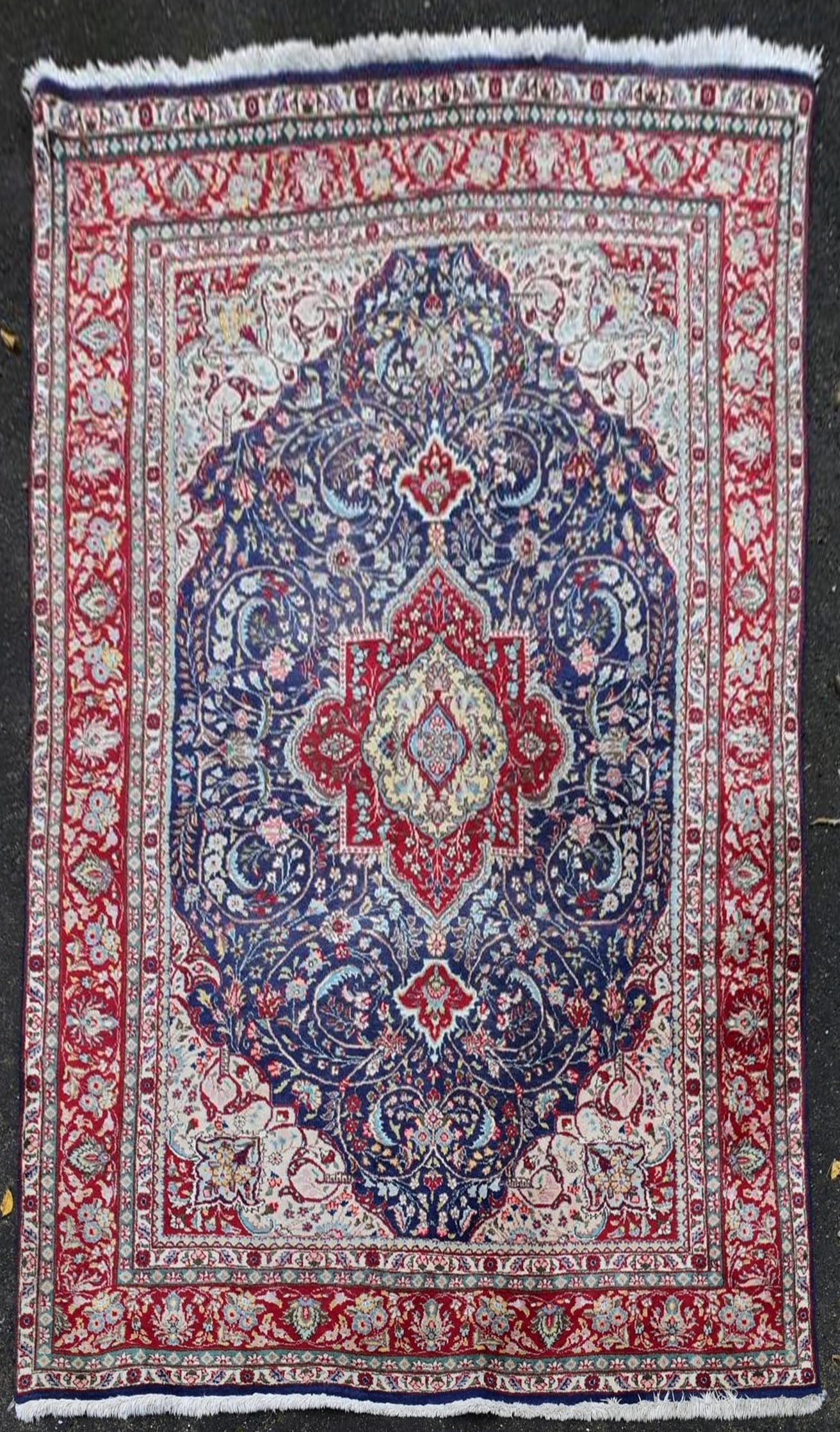 A Persian Keshan carpet with central floral medallion on sapphire ground within foliate multiple
