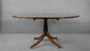 A Georgian style mahogany segment veneered and crossbanded dining table on quadruped swept supports.