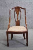 An Edwardian mahogany bedroom chair with scrolling ribbon and foliate inlay on tapering supports