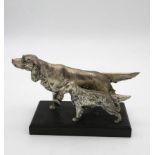 A silver plated Irish setter and puppy, intricately modelled mounted on a black wooden base. H.17