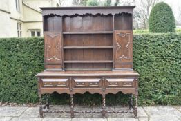 A late 19th century oak Jacobean style dresser with upper open plate rack fitted with lozenge