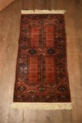 A rust ground Afghan style rug. H.180 W.86cm