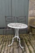 A white pierced metal garden table and two metal garden chairs. H.70 W.62cm (table)