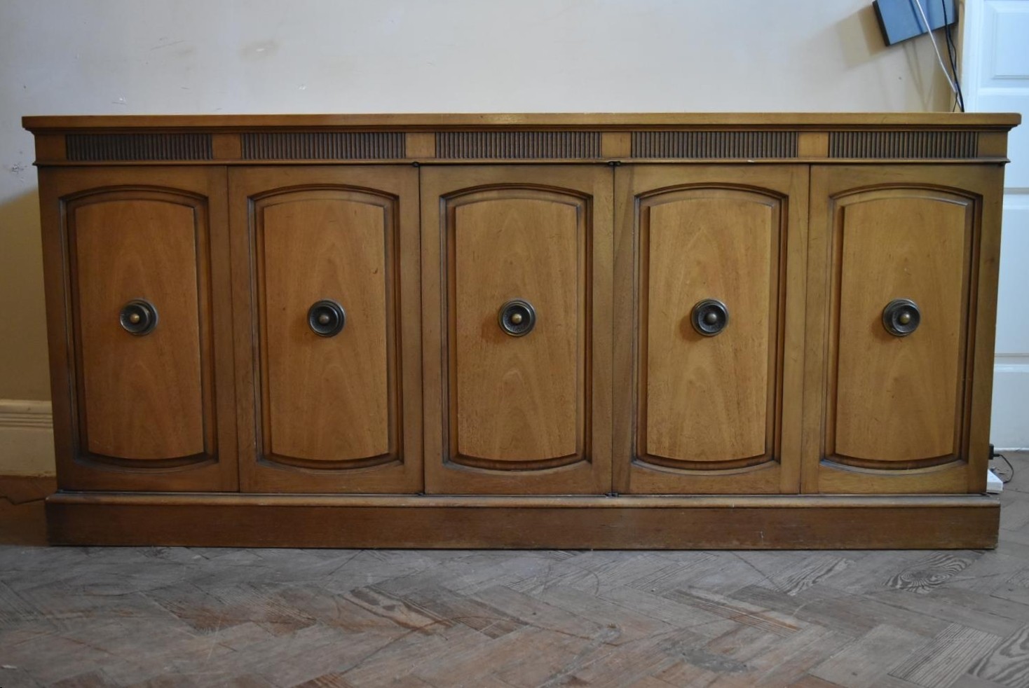 A walnut sideboard with panelled doors enclosing fitted interior on plinth base. H.76 W.170 D.48cm