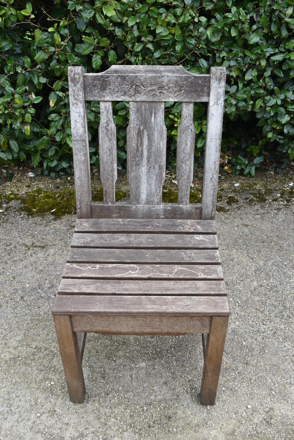 A set of four weathered teak garden chairs with carved back rails and slatted backs and seats on - Image 4 of 6