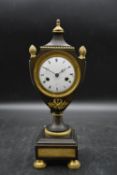 A 19th century French empire ormolu and bronze urn shaped mantel clock, with a white enamel dial and