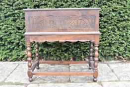 An 18th century carved oak bible box on base with turned stretchered supports. H.65 W.64 D.36cm