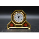 An early 20th century Royal Crown Derby clock with white enamel dial and stylised with gilded border