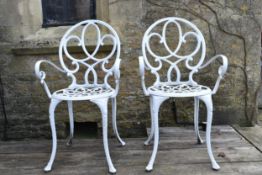 A pair of white metal garden armchairs. H.89 W.50cm