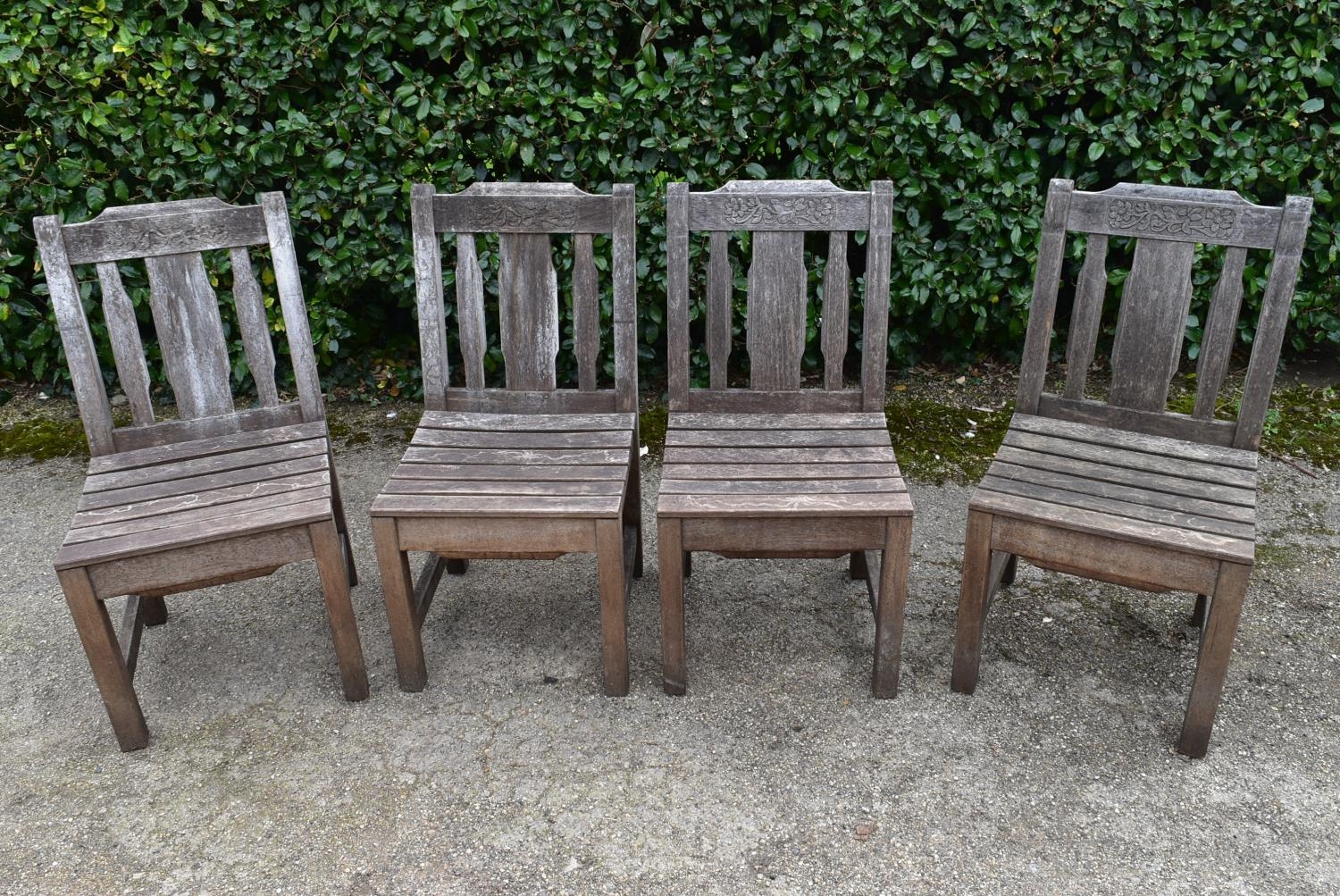 A set of four weathered teak garden chairs with carved back rails and slatted backs and seats on - Image 2 of 6