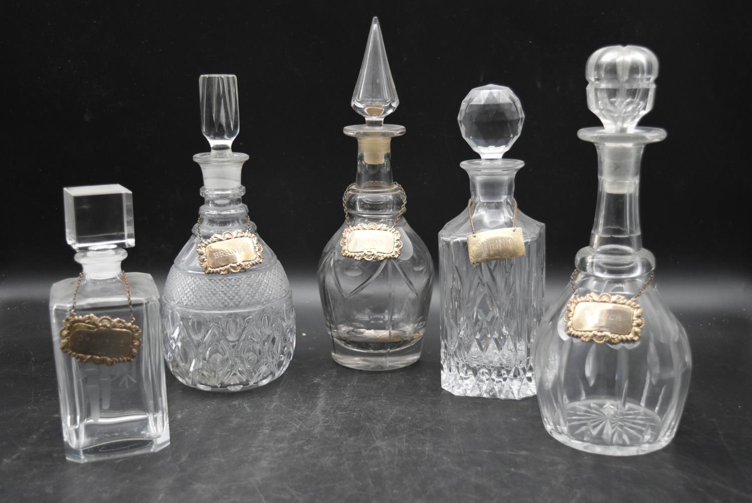 Five miscellaneous Victorian cut crystal glass decanters with silver drink labels. Hallmarked. H.