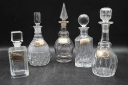 Five miscellaneous Victorian cut crystal glass decanters with silver drink labels. Hallmarked. H.