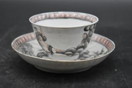 A Qing dynasty porcelain tea bowl and saucer decorated en grisaille, in red and black glaze depictin