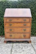 A mid century walnut and crossbanded bureau with fitted interior on bracket feet. H.105 W.76 D.45cm