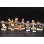 M.I Hummel - A collection of eleven vintage German porcelain figures. Including, little hiker,