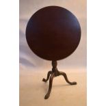 A Georgian mahogany tilt top table with bird cage action above baluster turned pedestal on tripod