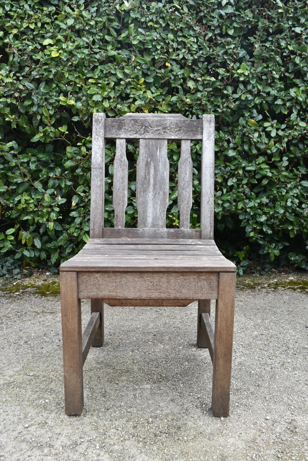 A set of four weathered teak garden chairs with carved back rails and slatted backs and seats on - Image 3 of 6