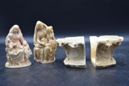 A collection of plaster replicas. Including two female figures holding children and a resin cast