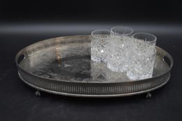 A 20th century silver plated tray with inlaid foliate decoration sitting on claw feet, along with