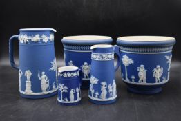 A collection of Wedgewood blue Jasperware to include two planters and three jugs with classical