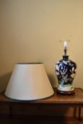 A contemporary baluster form table lamp with floral decoration and cream shade. H.60 W.22cm