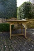 A weathered teak garden table with planked top on platform base. H.77 W.120 D.120cm