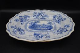 An early 20th century blue and white serving platter, with painted lake scene and floral designs,