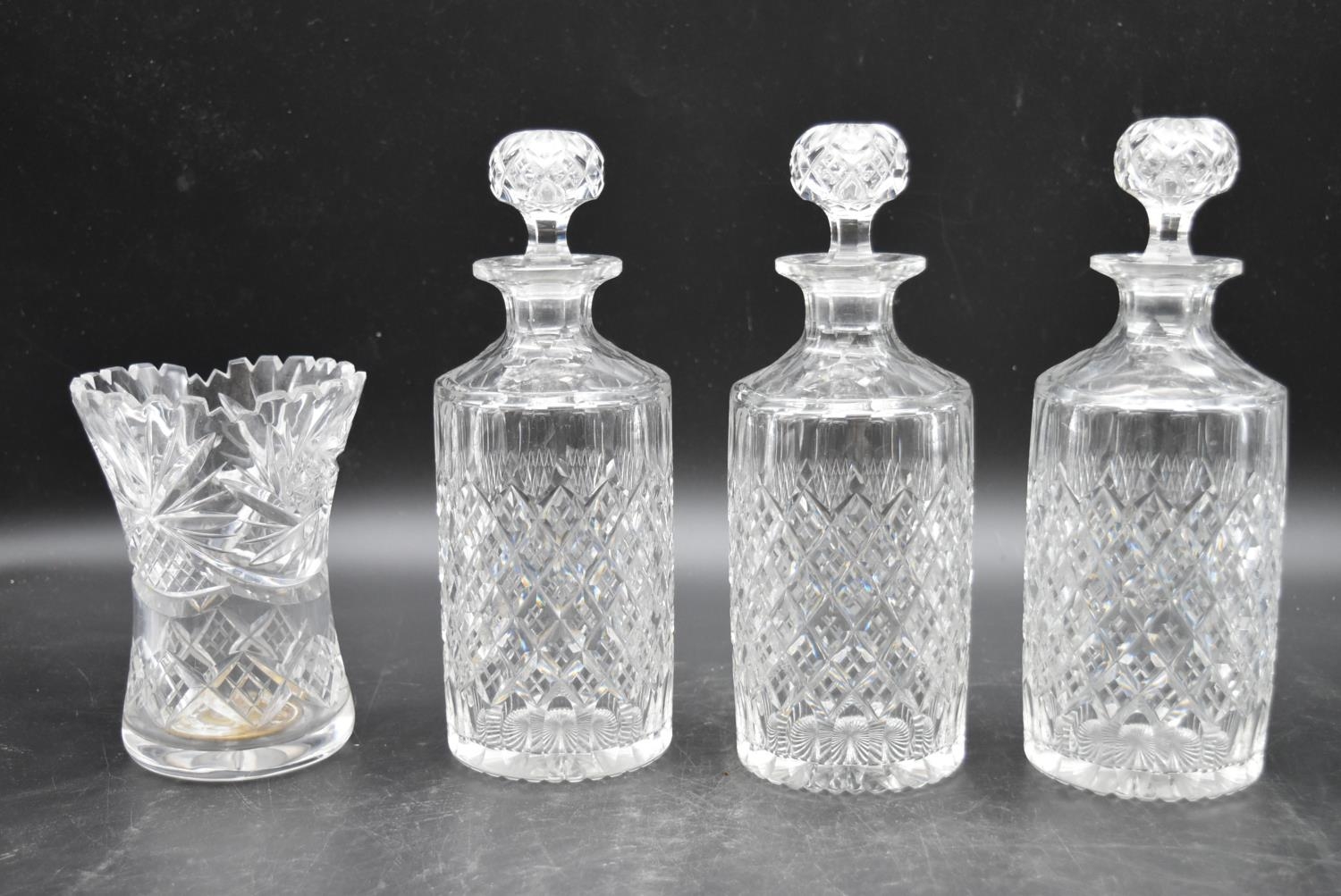 A set of three 20th century cut crystal glass topped decanters with a matching vase. H.27cm (