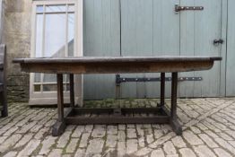 A large weathered teak garden table with a slatted top on square stretchered supports. H.85 W.135
