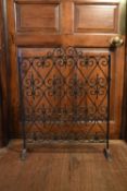 A wrought iron scrolling design fire guard. H.76 W.60cm