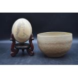 A 19th century scrimshaw Ostrich egg perched on mahogany stand and bowl