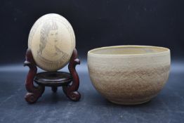 A 19th century scrimshaw Ostrich egg perched on mahogany stand and bowl
