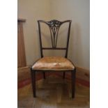 A late Victorian mahogany salon chair with floral carved splat back on square tapering supports. H.
