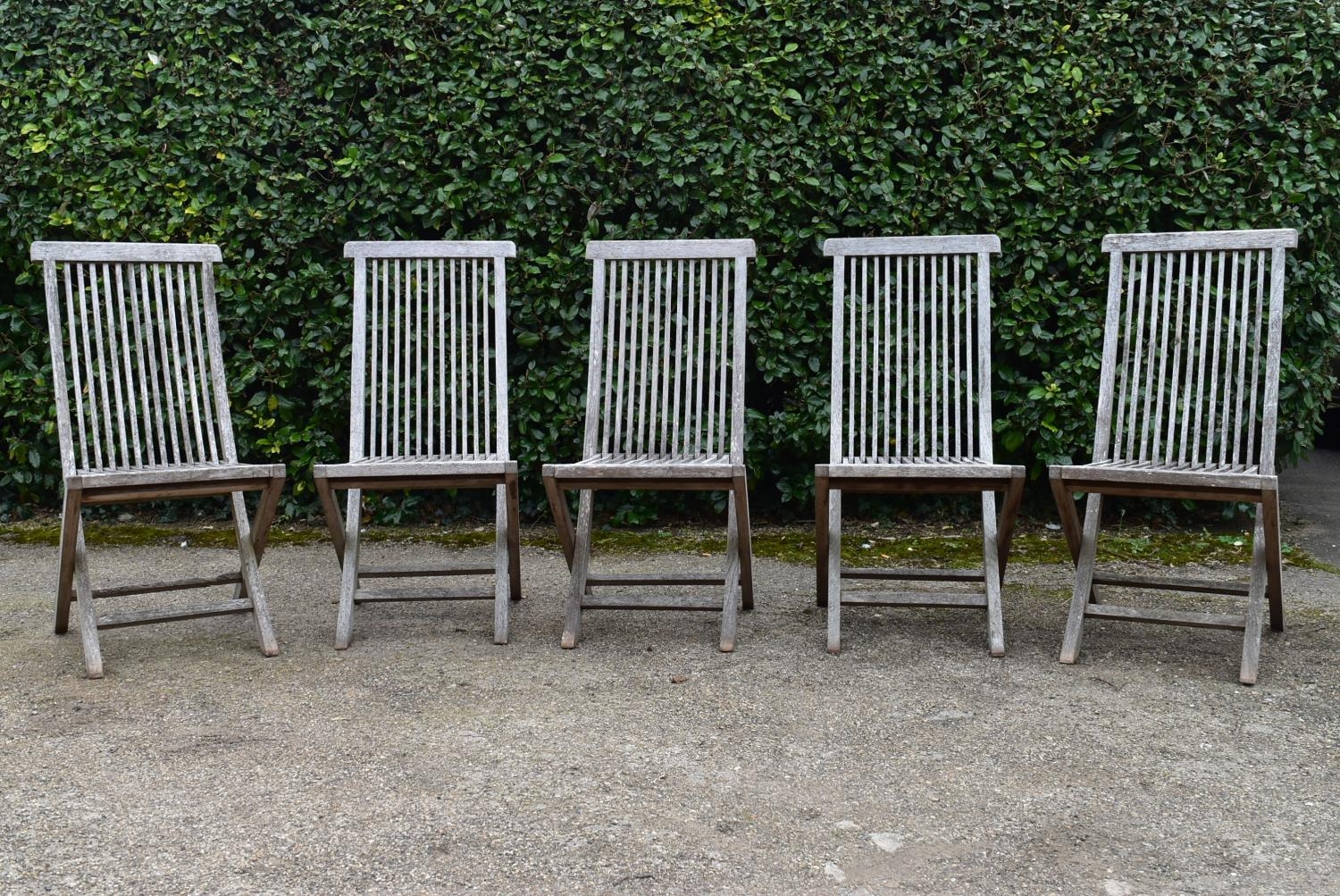 A set of five weathered teak folding and slatted garden chairs. H.99 W.46 D.43cm