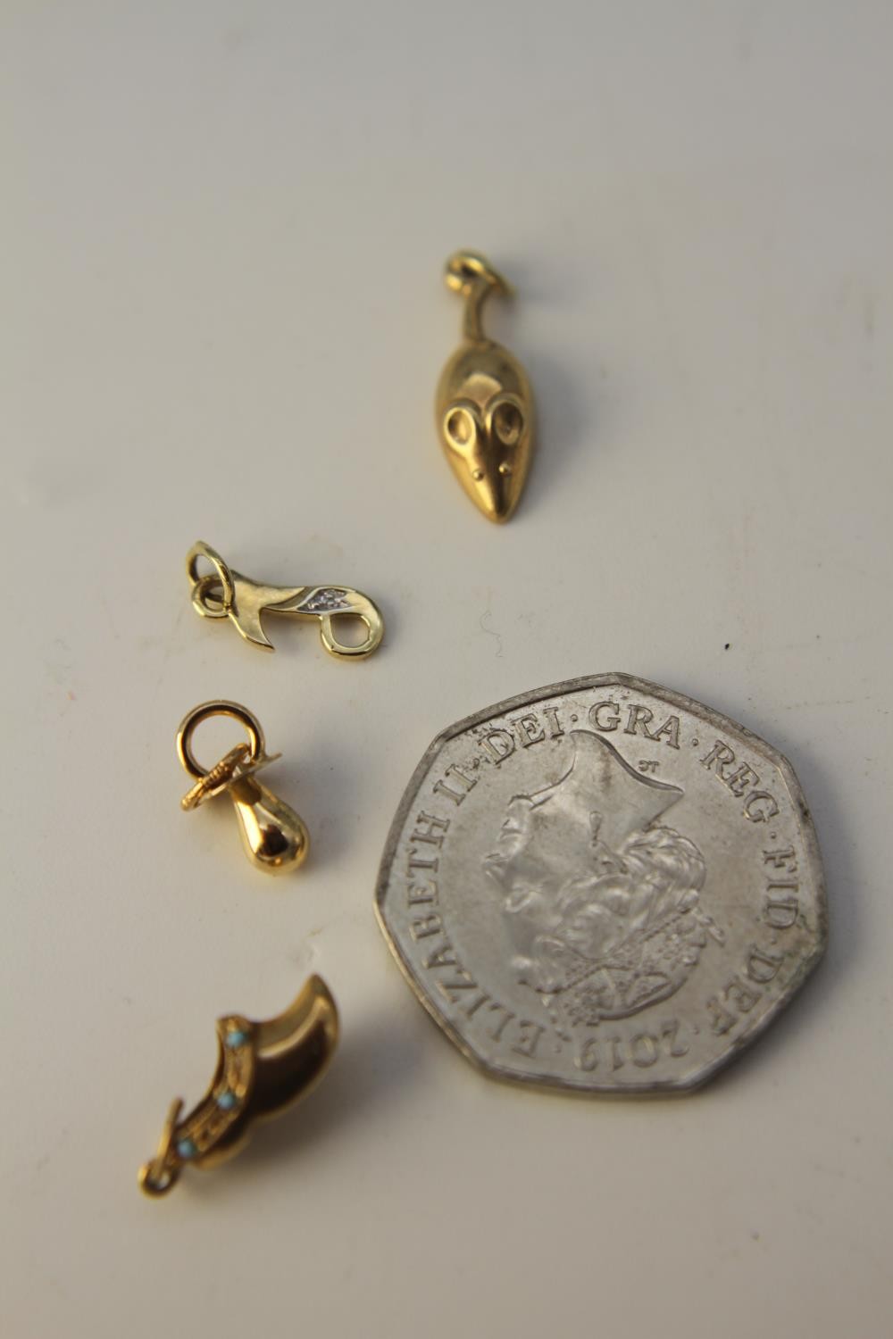 Four 14 carat yellow gold charms. Including a gold clog charm set with turquoise cabochons, a gold - Image 7 of 7
