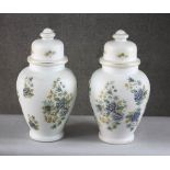 A pair of vintage frosted milk glass floral design lidded jars converted into table lamps. H.46