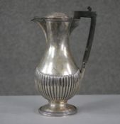 A Victorian sterling silver gadrooned coffee pot with ebony handle. Engraved coat of arms.