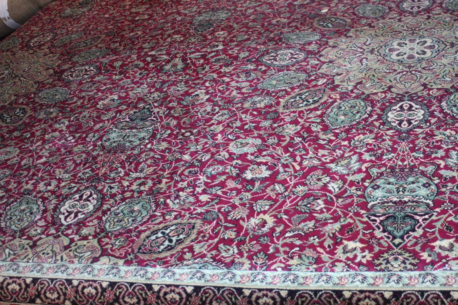 A large Wilton carpet with repeating floral medallions and trailing foliate decoration on a burgundy - Image 3 of 11