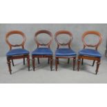 A set of four Victorian carved and shaped back mahogany dining chairs on turned tapering supports.