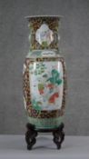 A large 19th century Chinese porcelain hand painted twin handled vase on carved harwood stand. The